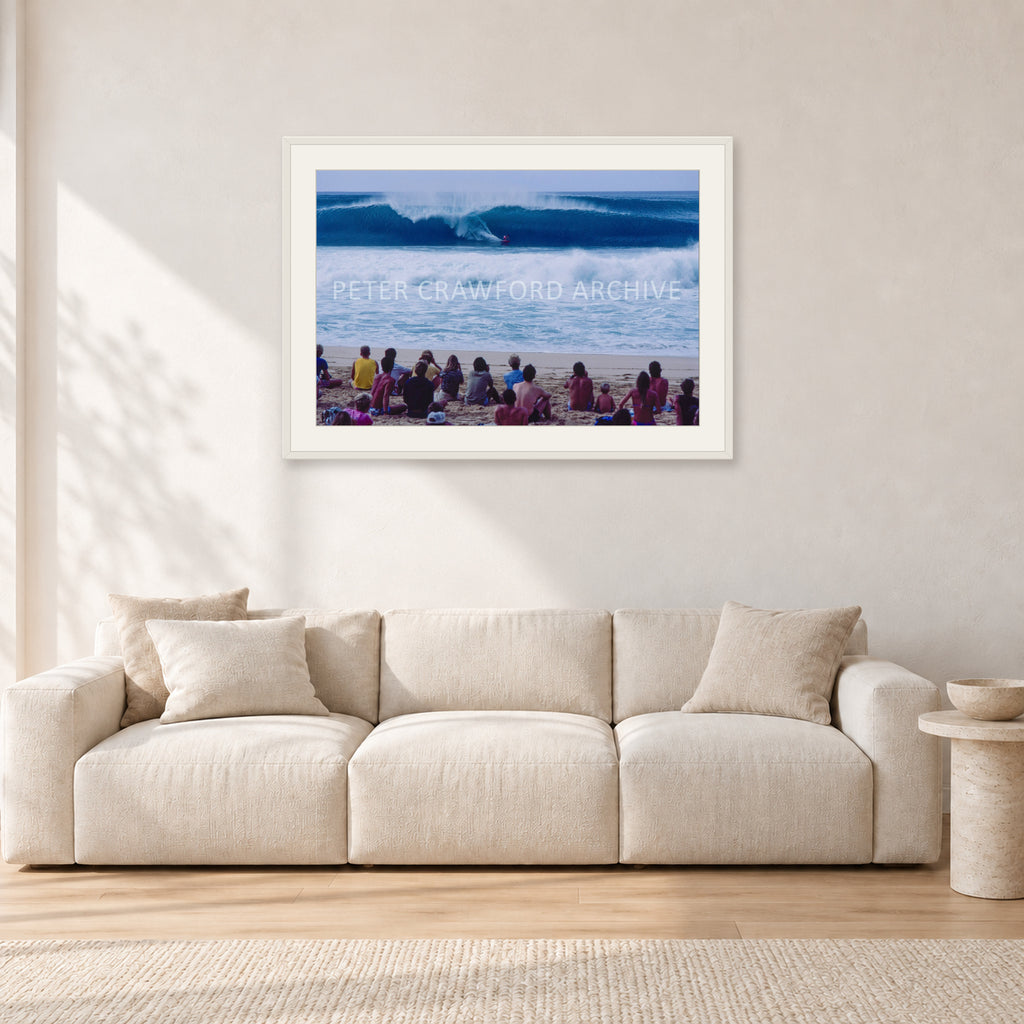 Pipe Masters, Pipeline 1988 by Peter Crawford — 90 × 60 cm, white frame with white mat, shown in a light minimalist living room.