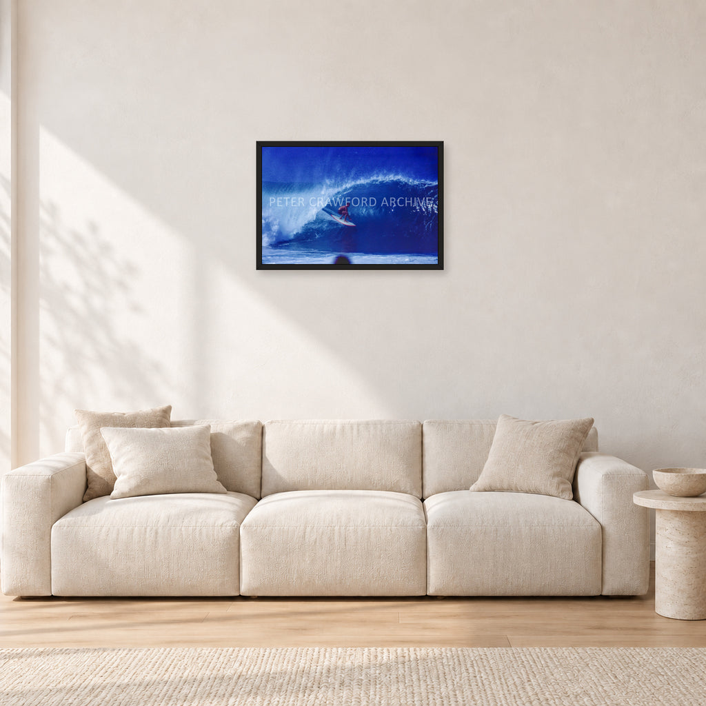 Pipeline, Hawaii by Peter Crawford — 60 × 40 cm, black frame, shown in a light minimalist living room.