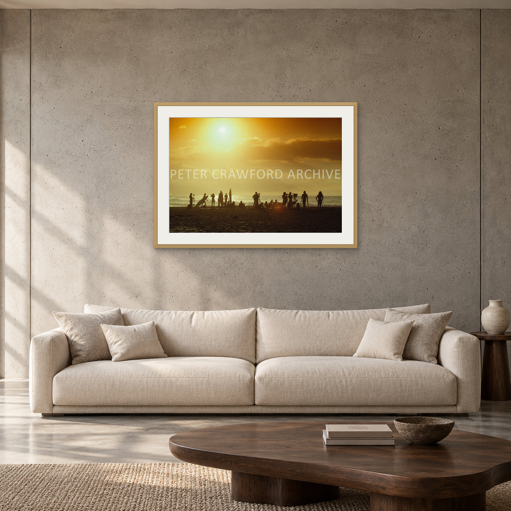 North Shore Sunset by Peter Crawford — 90 × 60 cm, hayseed frame with mat, shown to scale in a contemporary concrete-wall living room.
