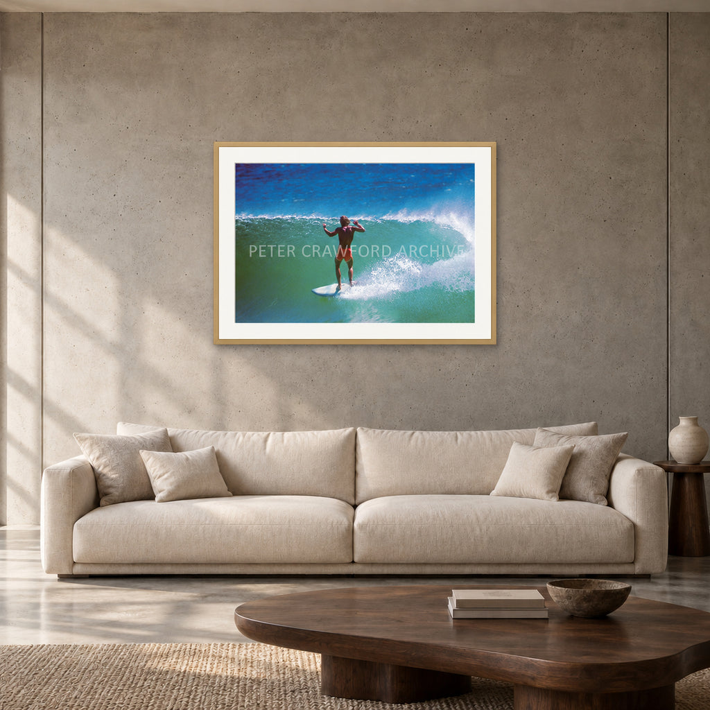 Terry Fitzgerald at Sunset Beach — 90 × 60 cm, hayseed frame with mat, shown in a contemporary concrete-wall living room.