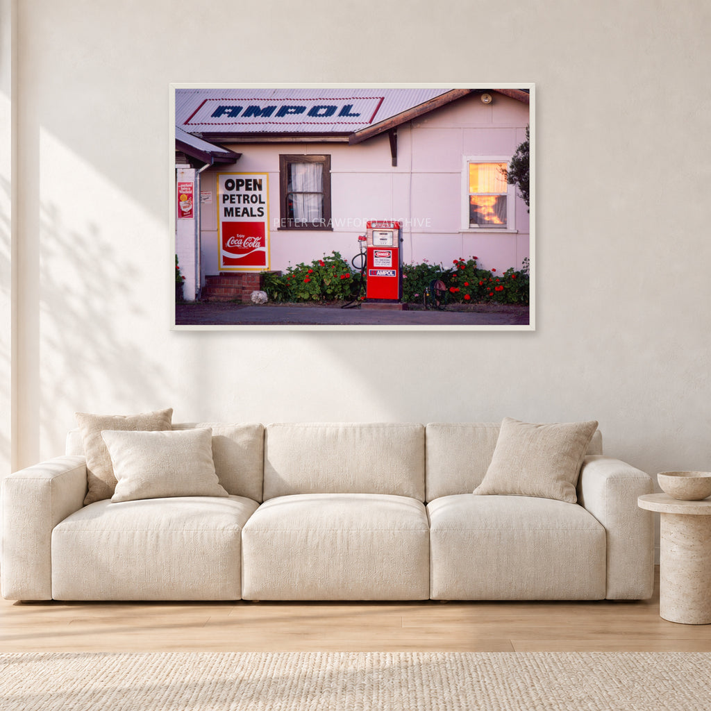 Seventies Petrol Station, 1970 by Peter Crawford — 120 × 80 cm, white frame, shown in a light minimalist living room.