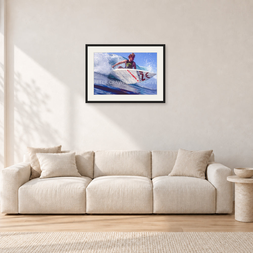 Shane Herring, Dee Why Point 1989 by Peter Crawford — 60 × 40 cm, black frame with white mat, shown in a light minimalist living room.