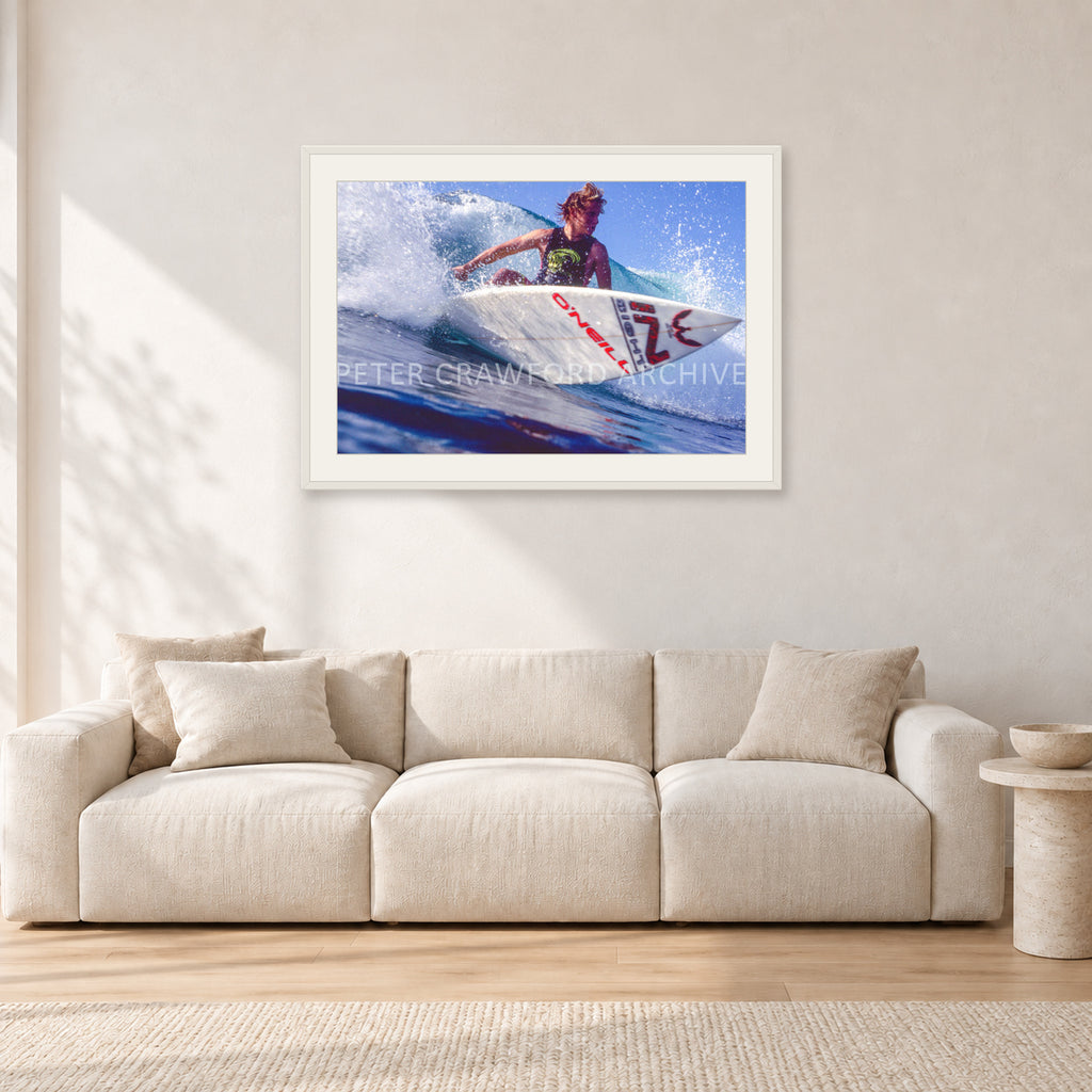 Shane Herring, Dee Why Point 1989 by Peter Crawford — 90 × 60 cm, white frame with white mat, shown in a light minimalist living room.