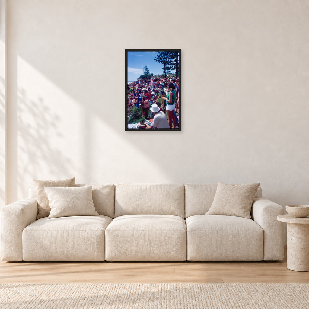 Stubbies Camera Crowd 78 Steve O'Ferral by Peter Crawford — 40 × 60 cm, black frame, shown in a light minimalist living room.