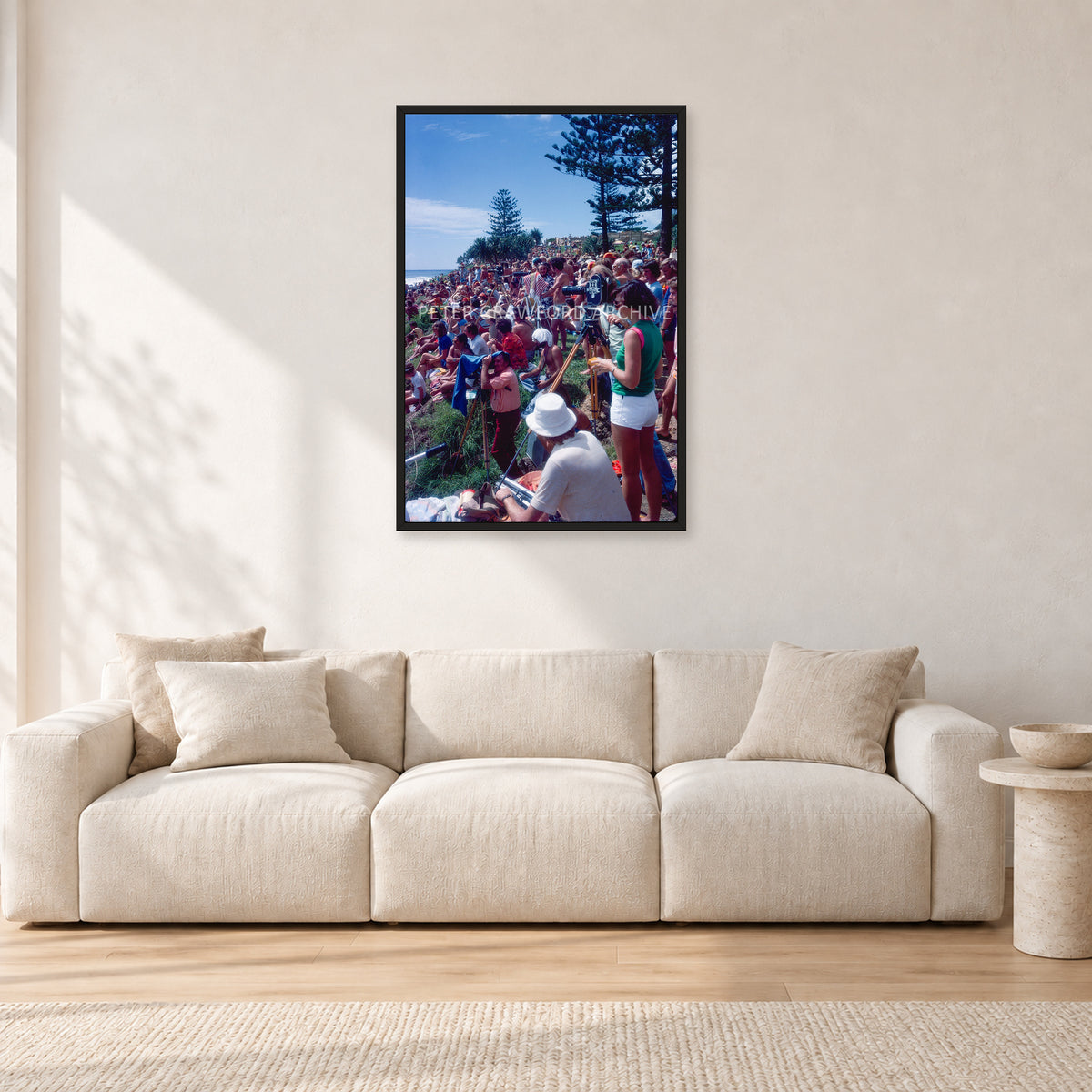 Stubbies Camera Crowd 78 Steve O'Ferral by Peter Crawford — 60 × 90 cm, black frame, shown in a light minimalist living room.