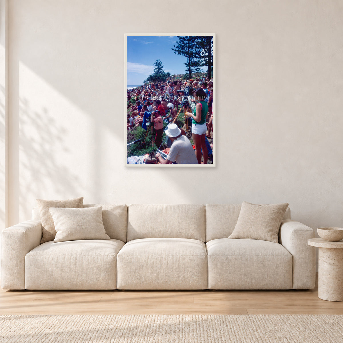 Stubbies Camera Crowd 78 Steve O'Ferral by Peter Crawford — 60 × 90 cm, white frame, shown in a light minimalist living room.