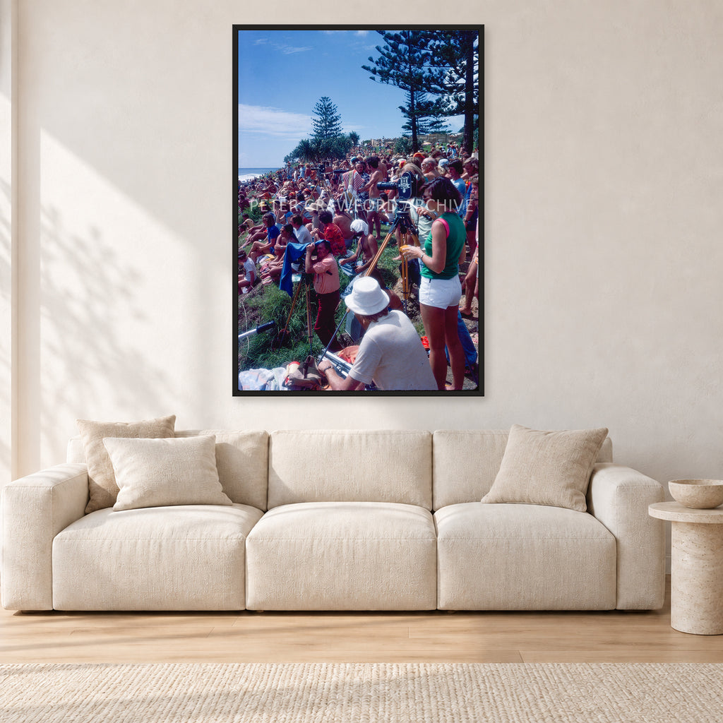 Stubbies Camera Crowd 78 Steve O'Ferral by Peter Crawford — 80 × 120 cm, black frame, shown in a light minimalist living room.