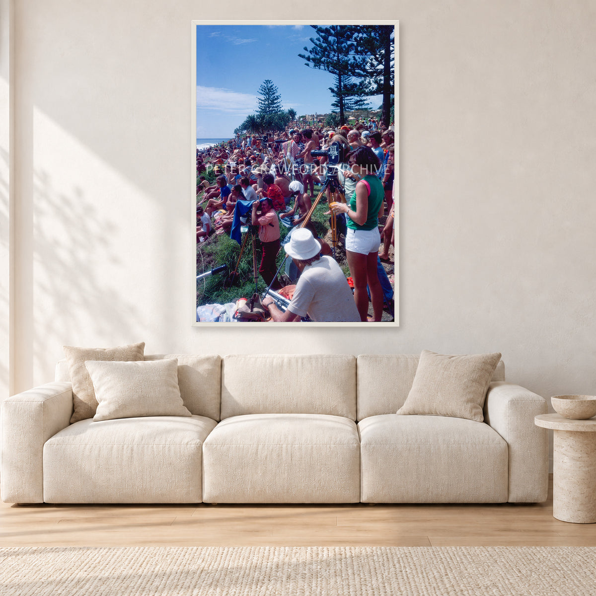 Stubbies Camera Crowd 78 Steve O'Ferral by Peter Crawford — 80 × 120 cm, white frame, shown in a light minimalist living room.