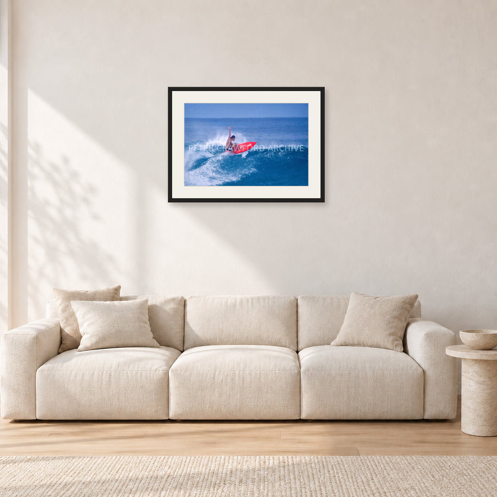 Sunset Beach, Hawaii by Peter Crawford — 60 × 40 cm, black frame with white mat, shown in a light minimalist living room.