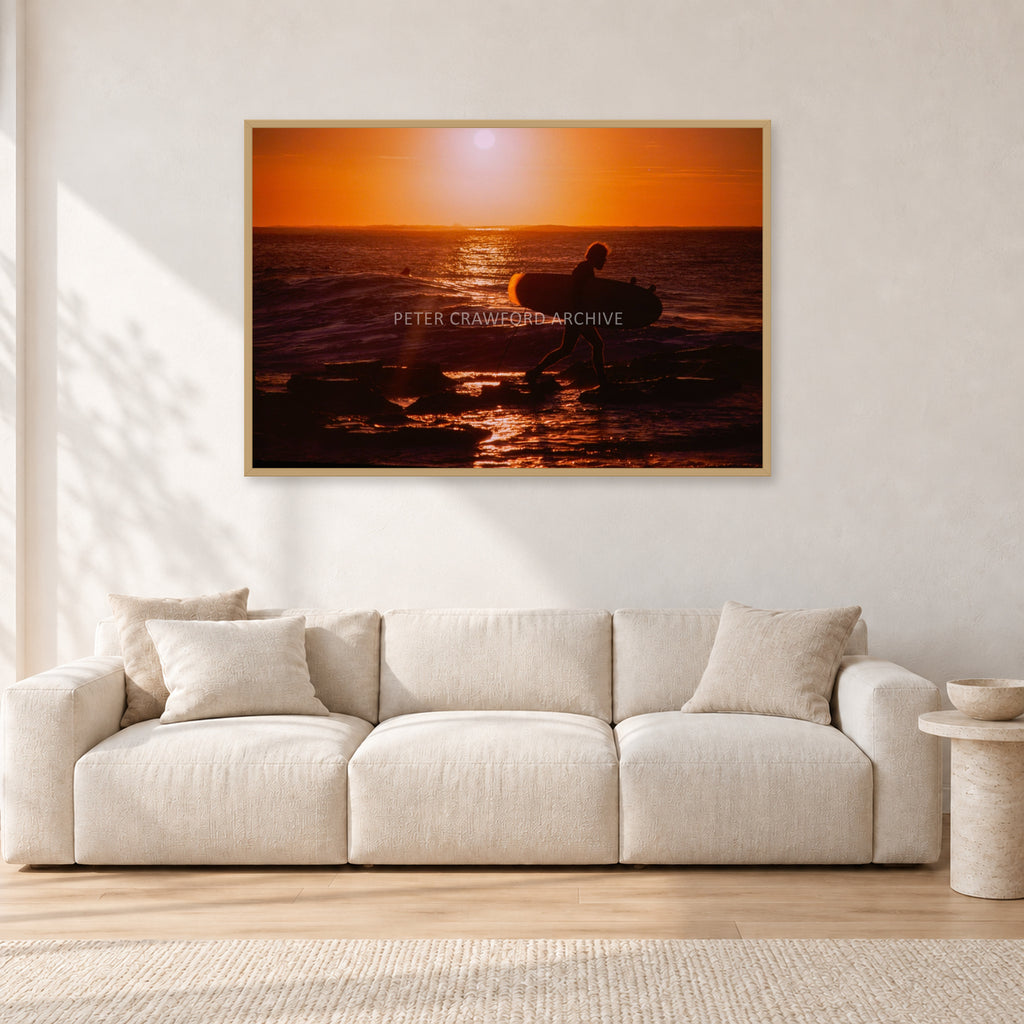 Sunset X1 by Peter Crawford — 120 × 80 cm, hayseed frame, shown in a light minimalist living room.