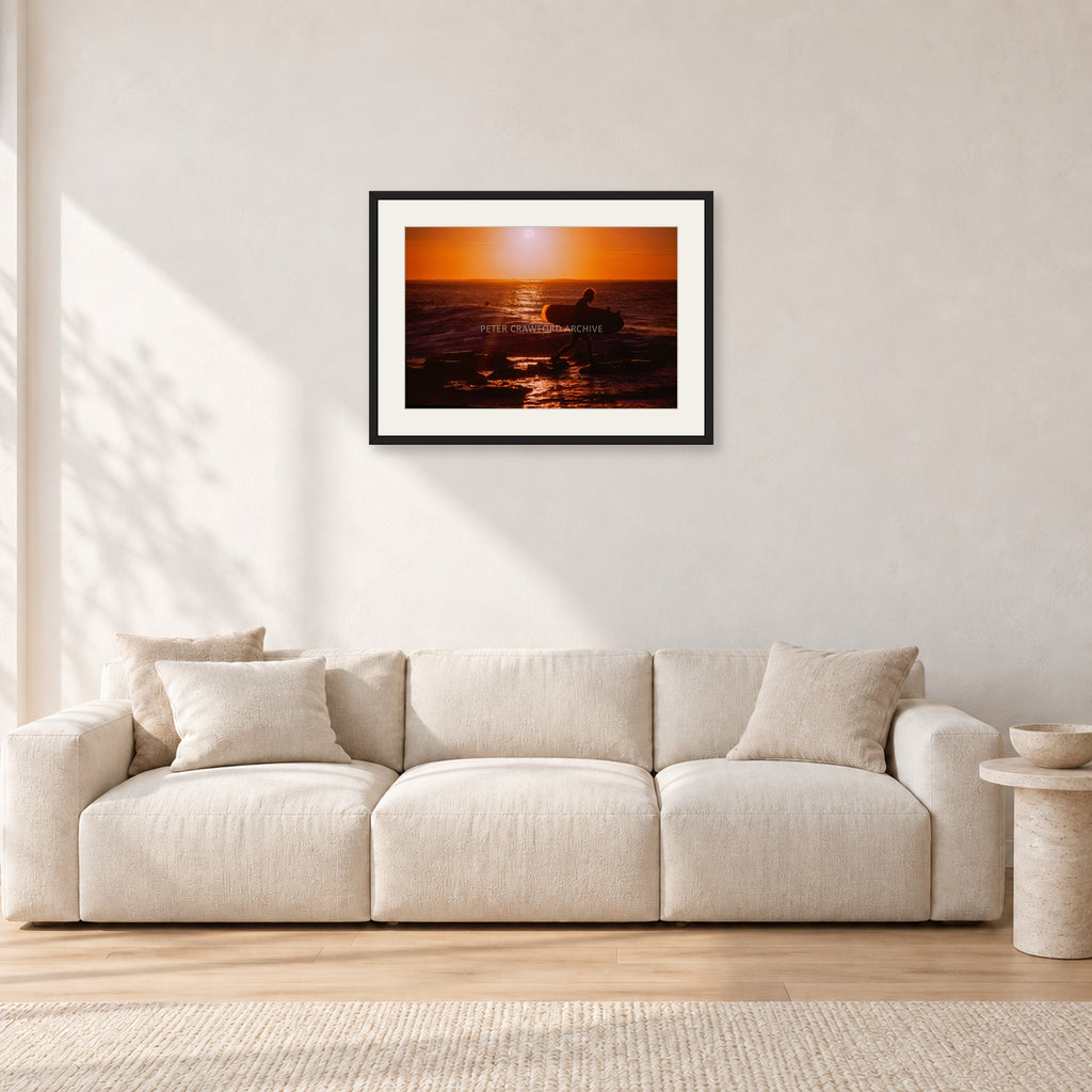 Sunset X1 by Peter Crawford — 60 × 40 cm, black frame with white mat, shown in a light minimalist living room.