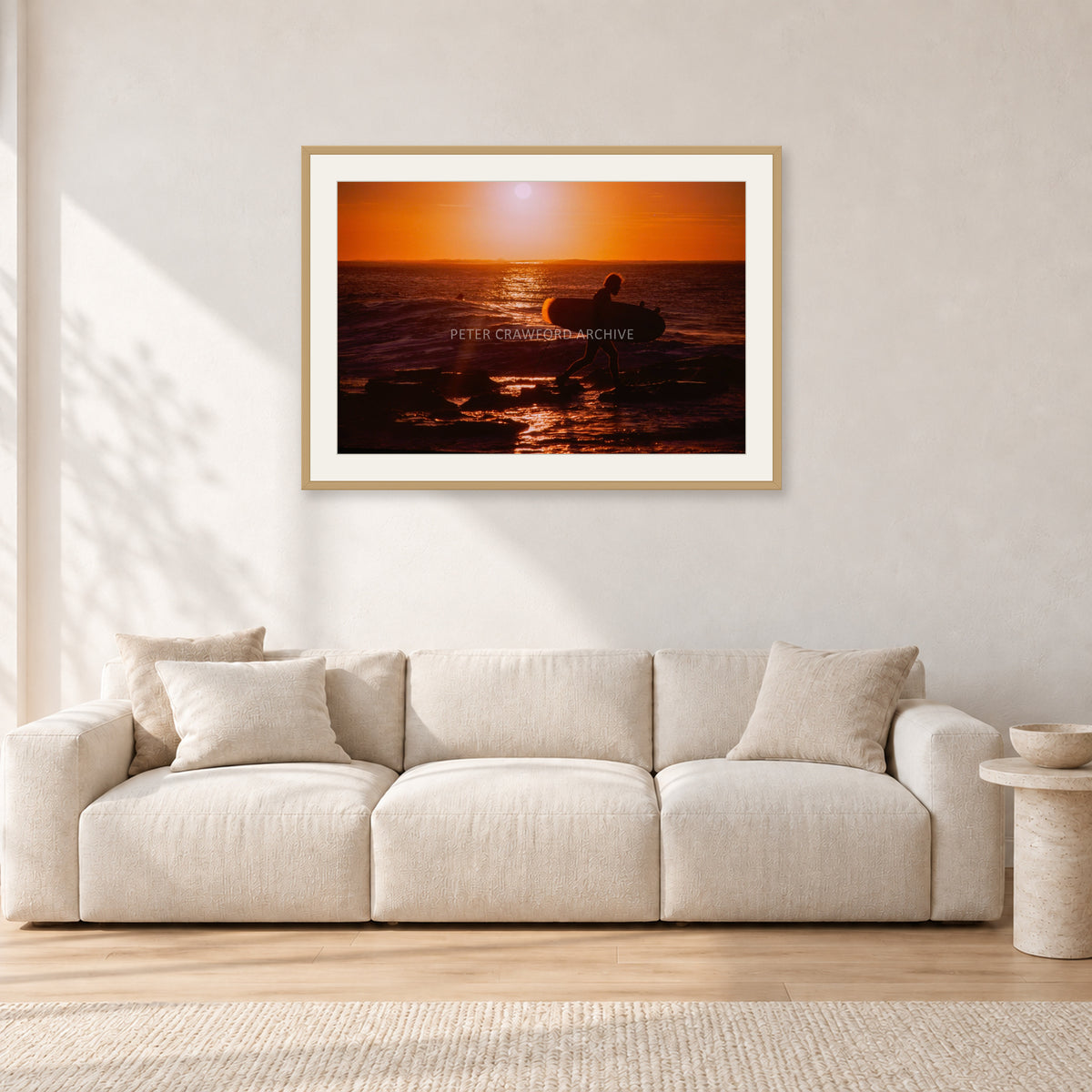 Sunset X1 by Peter Crawford — 90 × 60 cm, hayseed frame with white mat, shown in a light minimalist living room.