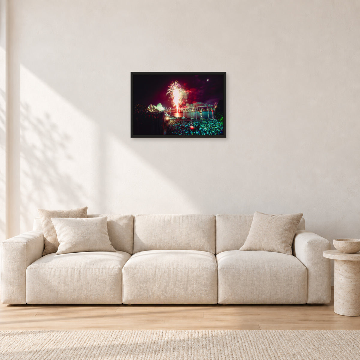 Tom Carroll and Aaron Chang, Waimea 1985 by Peter Crawford — 60 × 40 cm, black frame, shown in a light minimalist living room.