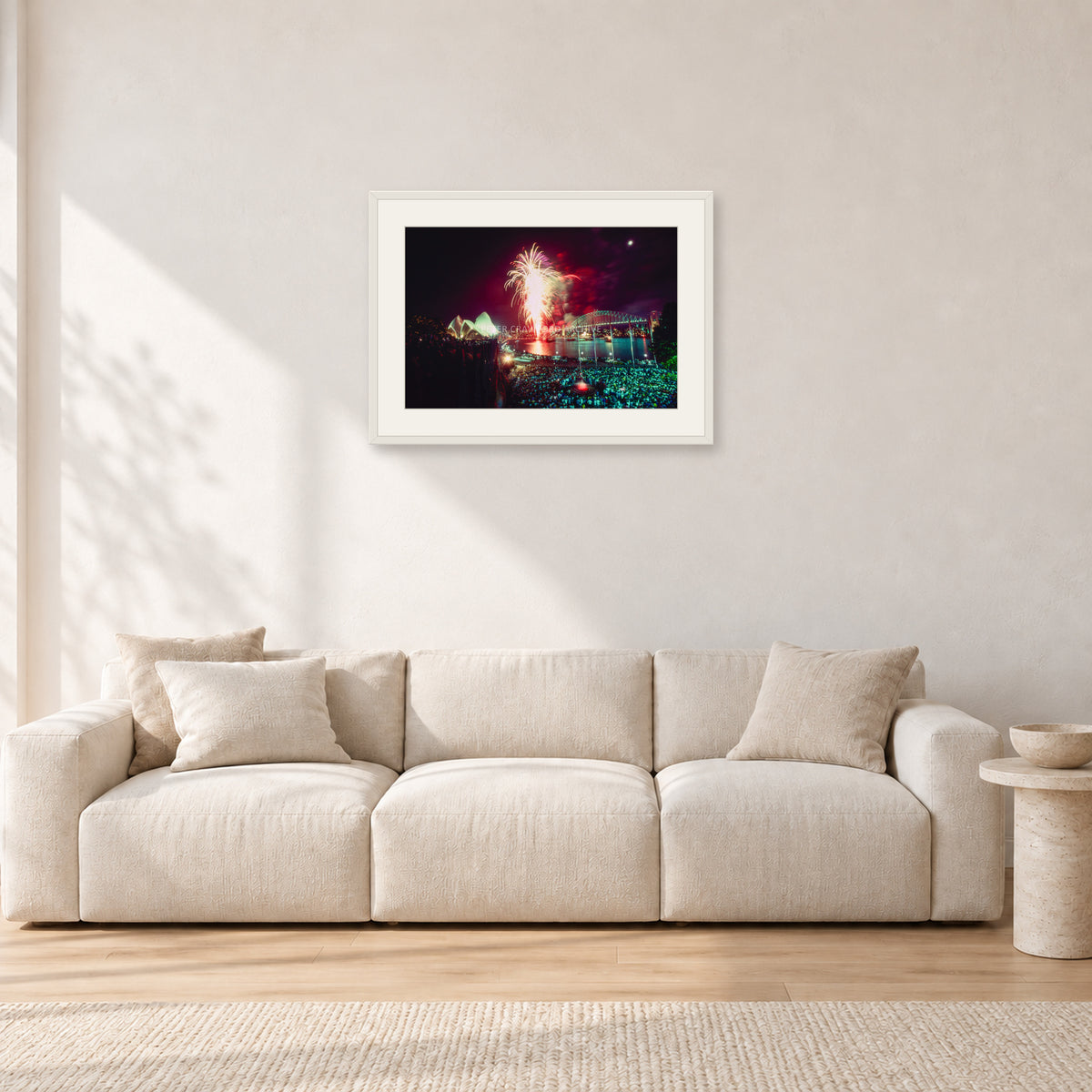 Tom Carroll and Aaron Chang, Waimea 1985 by Peter Crawford — 60 × 40 cm, white frame with white mat, shown in a light minimalist living room.