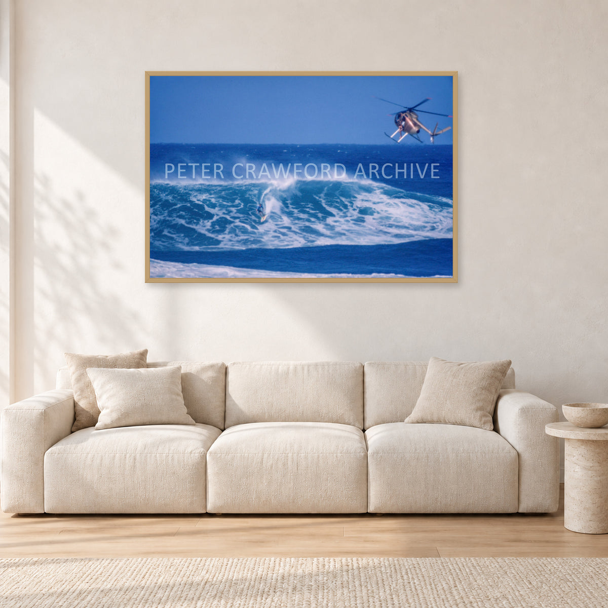 Tom Carroll, Sunset Beach Aerial by Peter Crawford — 120 × 80 cm, hayseed frame, shown in a light minimalist living room.