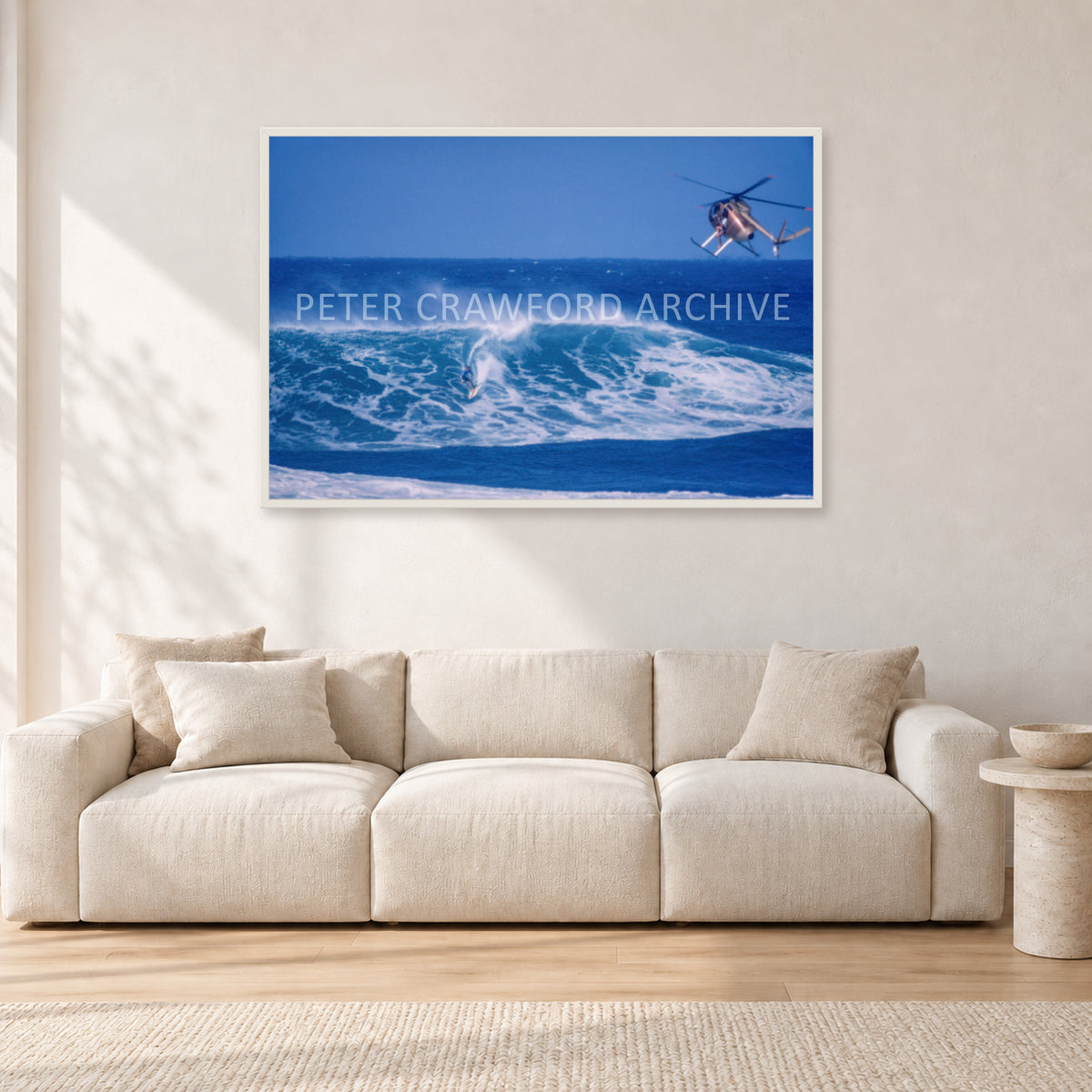 Tom Carroll, Sunset Beach Aerial by Peter Crawford — 120 × 80 cm, white frame, shown in a light minimalist living room.