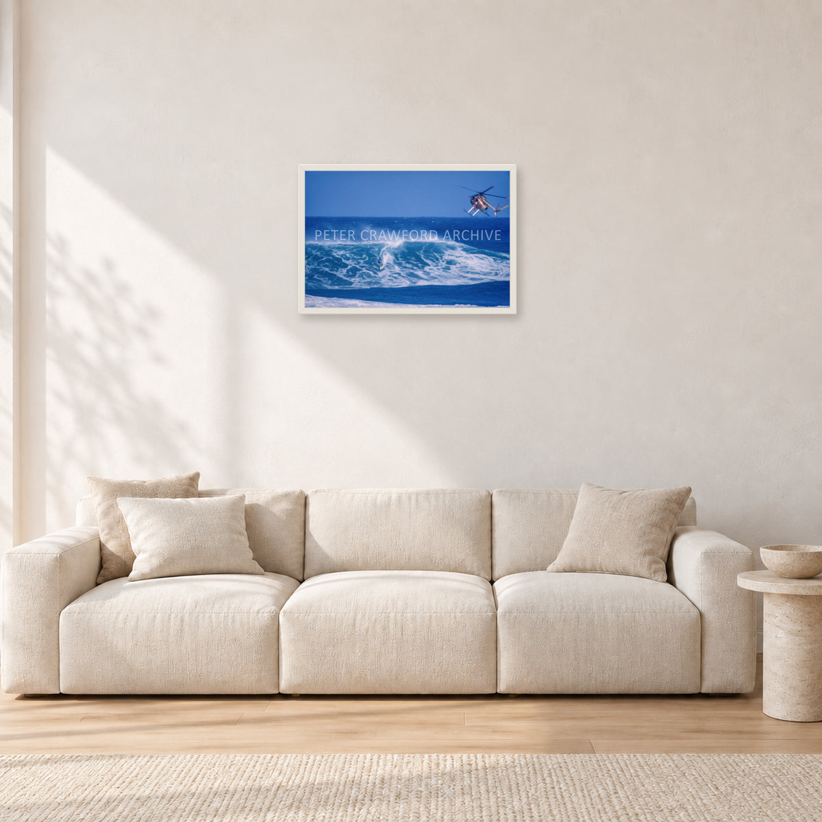 Tom Carroll, Sunset Beach Aerial by Peter Crawford — 60 × 40 cm, white frame, shown in a light minimalist living room.