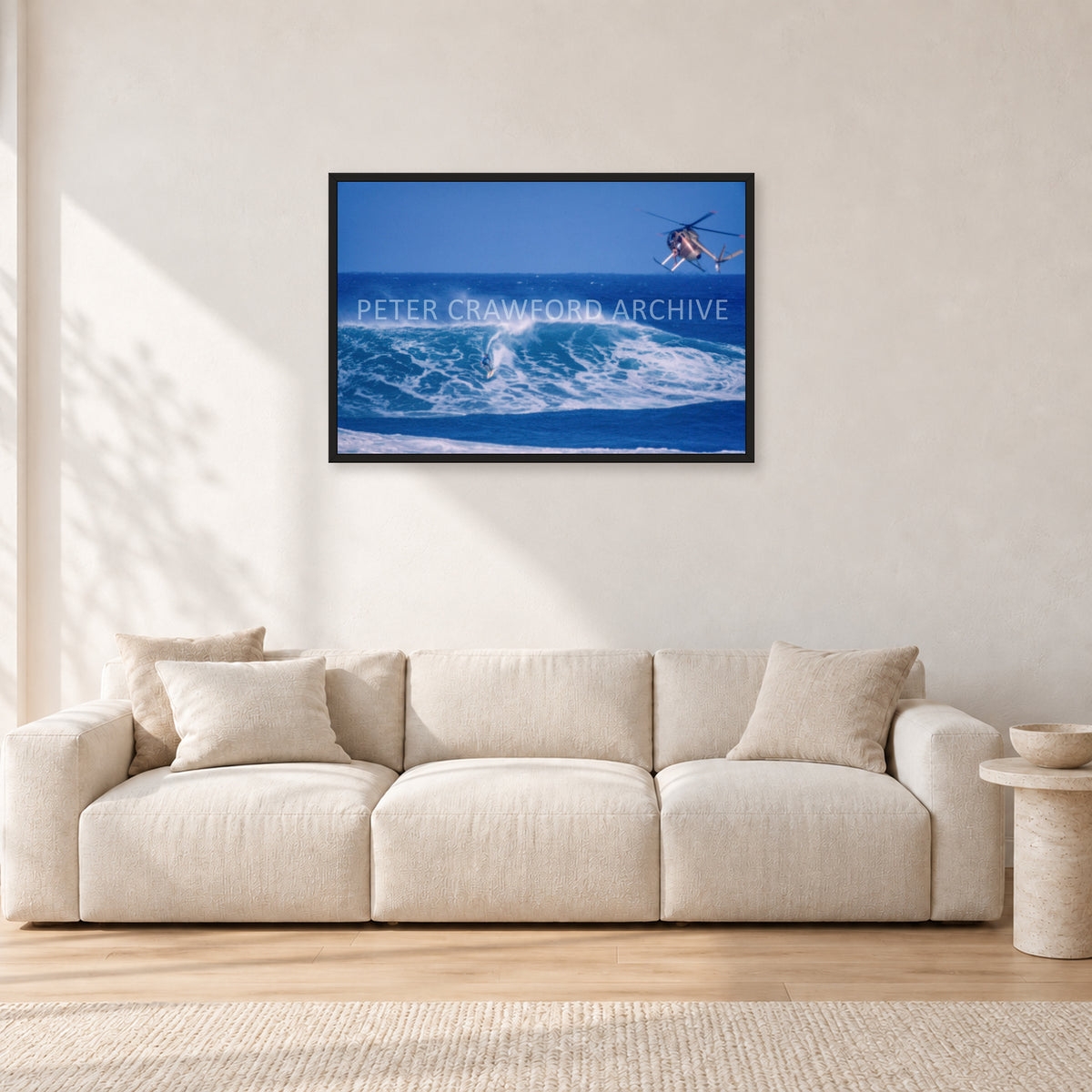 Tom Carroll, Sunset Beach Aerial by Peter Crawford — 90 × 60 cm, black frame, shown in a light minimalist living room.