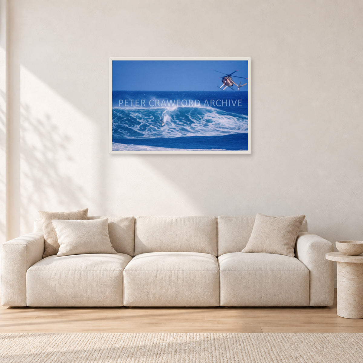 Tom Carroll, Sunset Beach Aerial by Peter Crawford — 90 × 60 cm, white frame, shown in a light minimalist living room.
