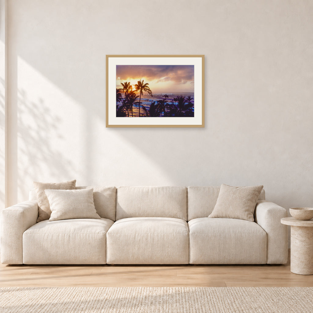 Turtle Bay Dusk by Peter Crawford — 60 × 40 cm, hayseed frame with white mat, shown in a light minimalist living room.