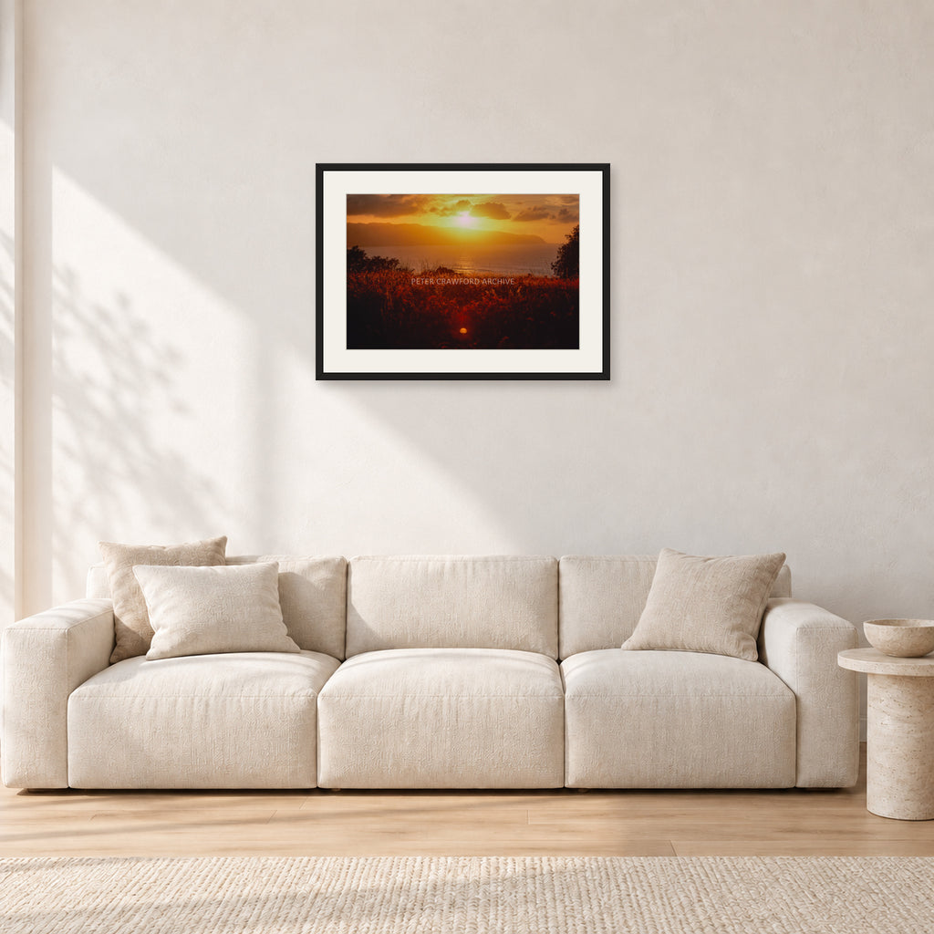 Waimea Dusk by Peter Crawford — 60 × 40 cm, black frame with white mat, shown in a light minimalist living room.