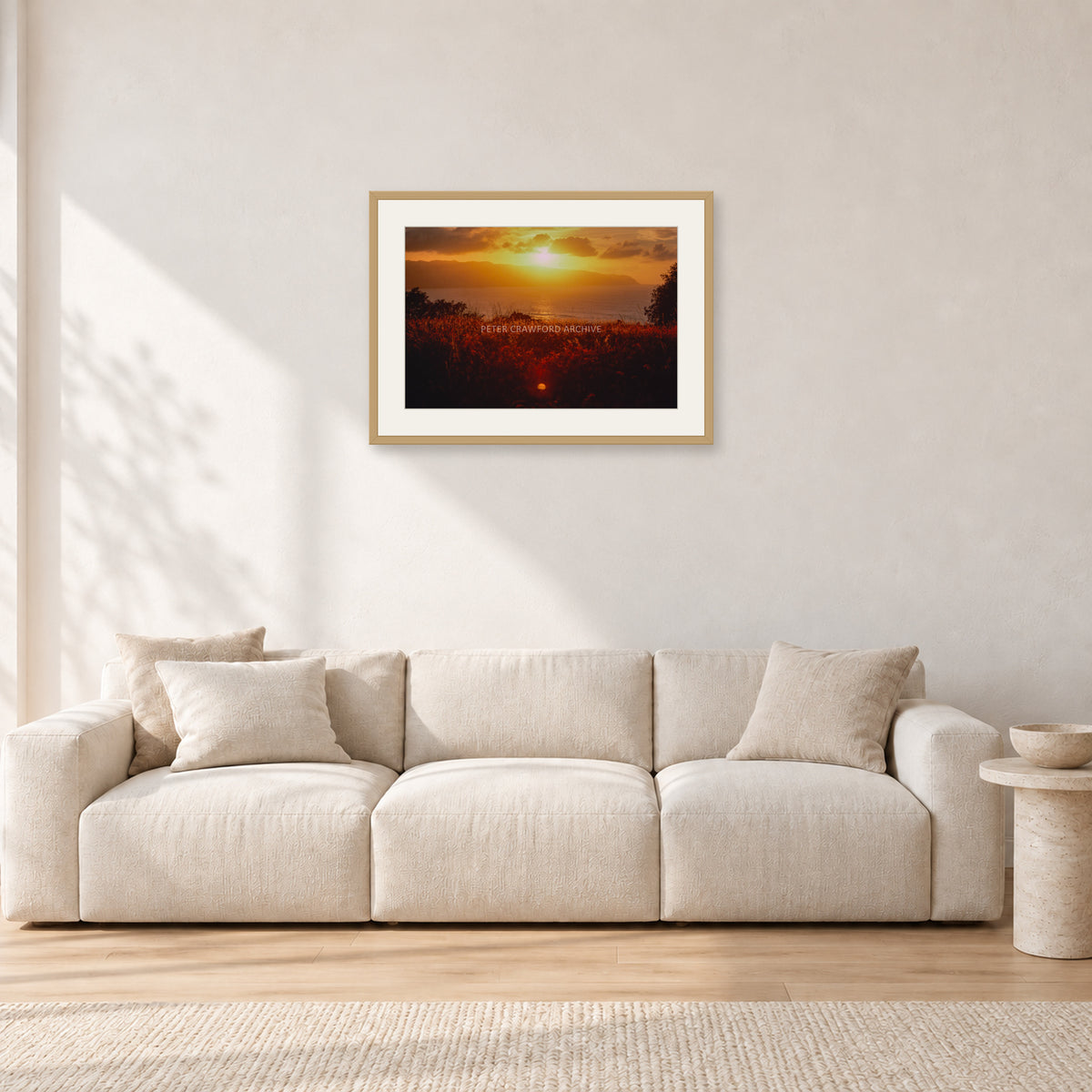 Waimea Dusk by Peter Crawford — 60 × 40 cm, hayseed frame with white mat, shown in a light minimalist living room.