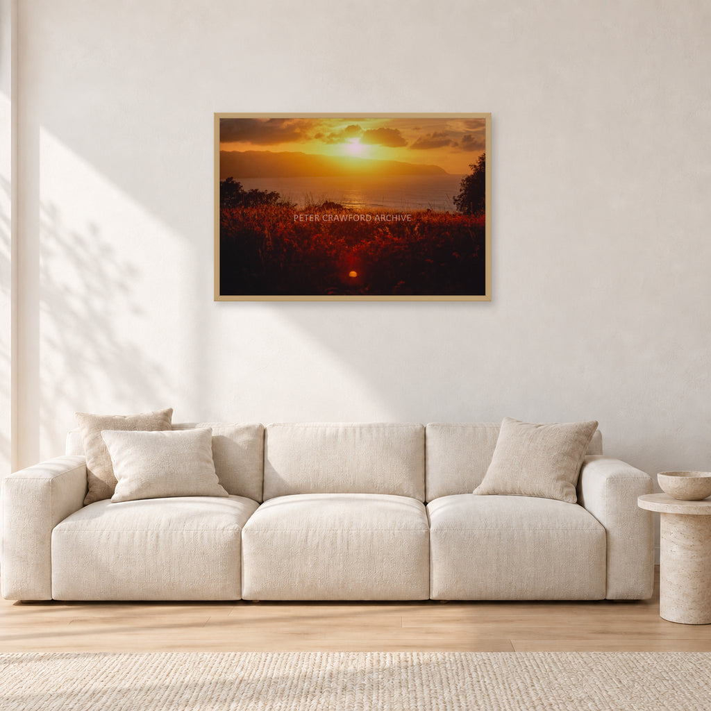 Waimea Dusk by Peter Crawford — 90 × 60 cm, hayseed frame, shown in a light minimalist living room.