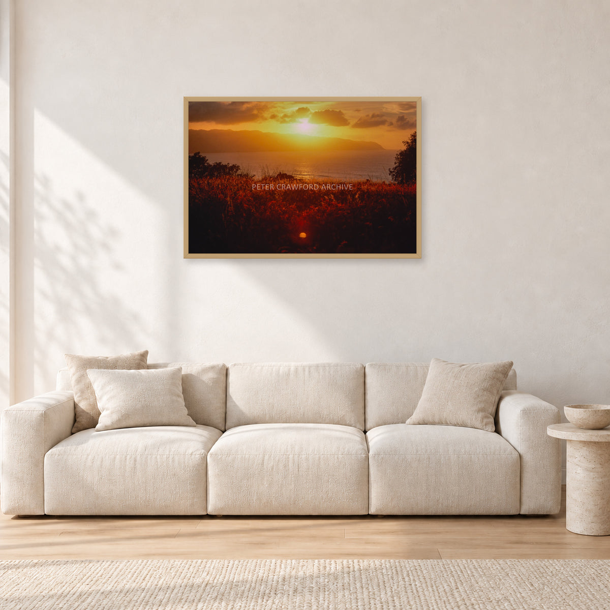 Waimea Dusk by Peter Crawford — 90 × 60 cm, hayseed frame, shown in a light minimalist living room.