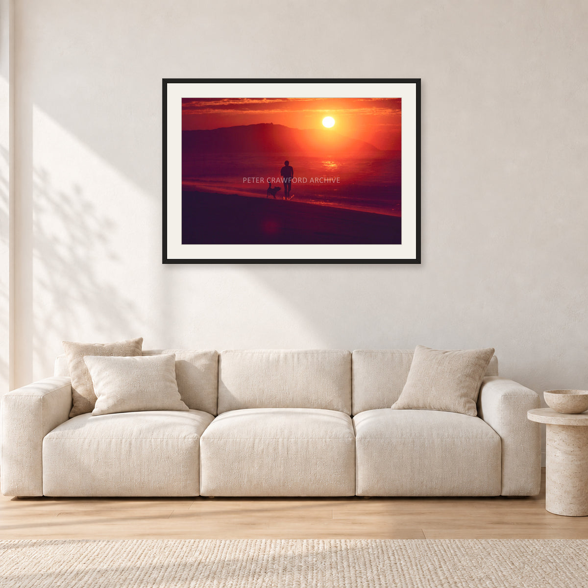 Winter Sun, Collaroy by Peter Crawford — 90 × 60 cm, black frame with white mat, shown in a light minimalist living room.